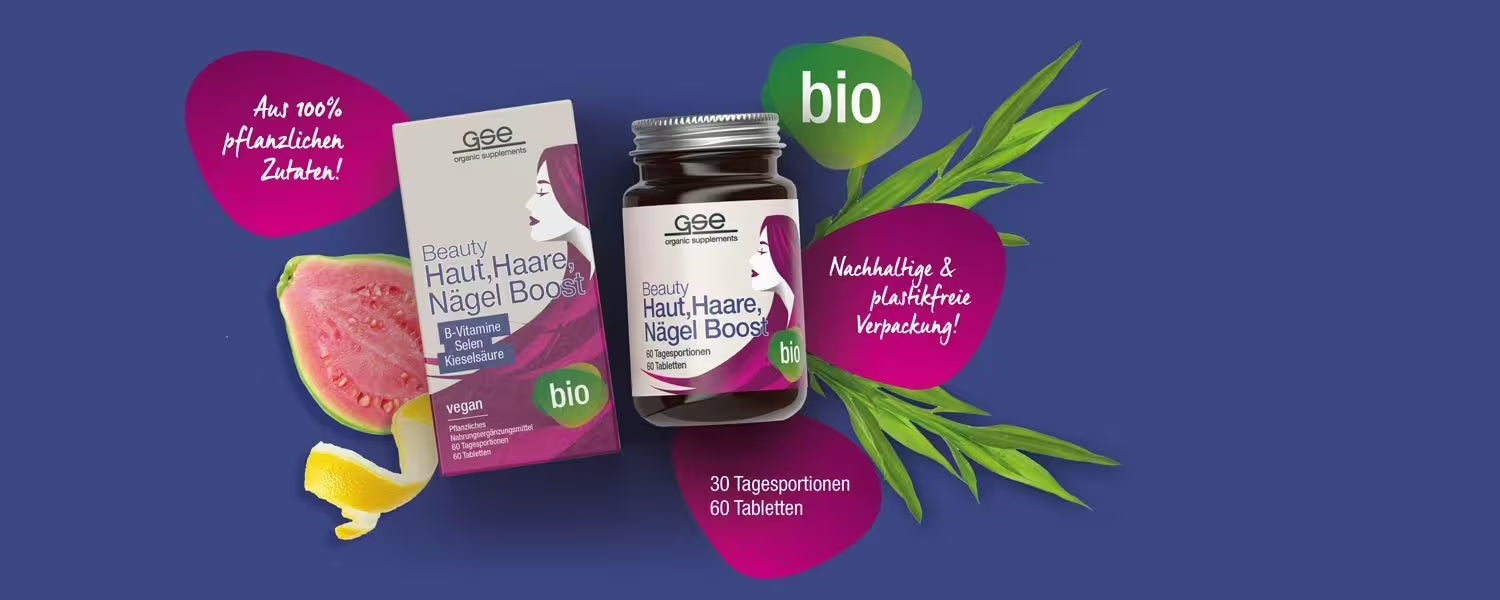 Ein Glas und eine Schachtel mit veganen Bio-Tabletten „Beauty Haut, Haare, Nägel Boost“ sind mit Fruchtscheiben und grünen Blättern auf violettem Hintergrund abgebildet. Der Text hebt die pflanzlichen Inhaltsstoffe und die nachhaltige Verpackung hervor.