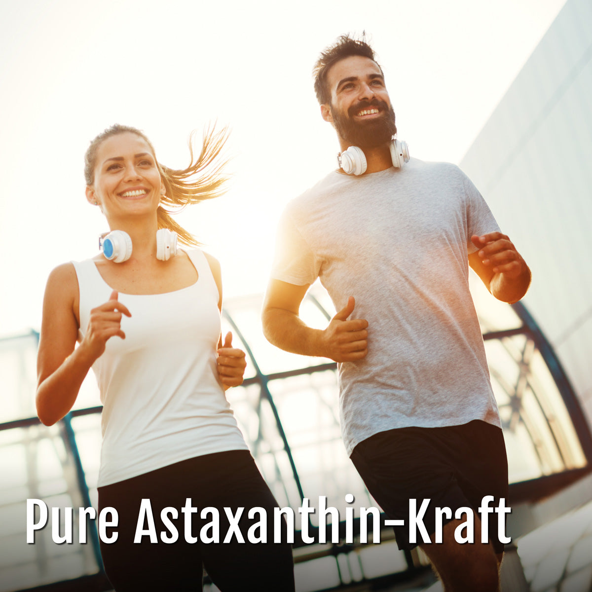 Ein lächelnder Mann und eine lächelnde Frau mit Kopfhörern um den Hals, die gemeinsam im Freien joggen; unten ist der Text Astaxanthin-Oleoresin-Kapseln (Bio) eingeblendet.