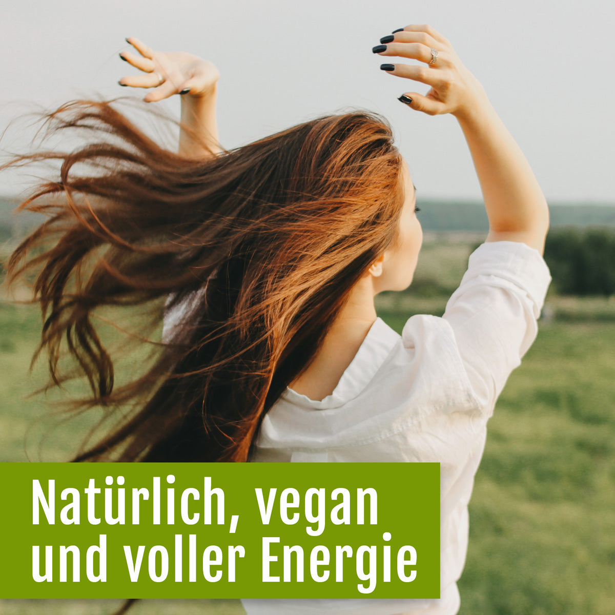 Eine Frau mit langen braunen Haaren und einem weißen Hemd tanzt draußen auf einer Wiese. Der deutsche Text lautet: „Natürlich, vegan und voller Energie – Naturland Bio-Chlorella (Tabletten) mit Vitamin B12 von gse.organic.supplements“ auf grünem Hintergrund.