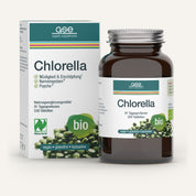Eine braune Glasflasche und ein Umkarton von Naturland Bio Chlorella (Tabletten) von gse.organic.supplements, die als vegan, glutenfrei, laktosefrei und reich an Vitamin B12 gekennzeichnet sind. Die Verpackung ist weiß mit grünen Akzenten und Abbildungen von grünen Chlorella-Tabletten.