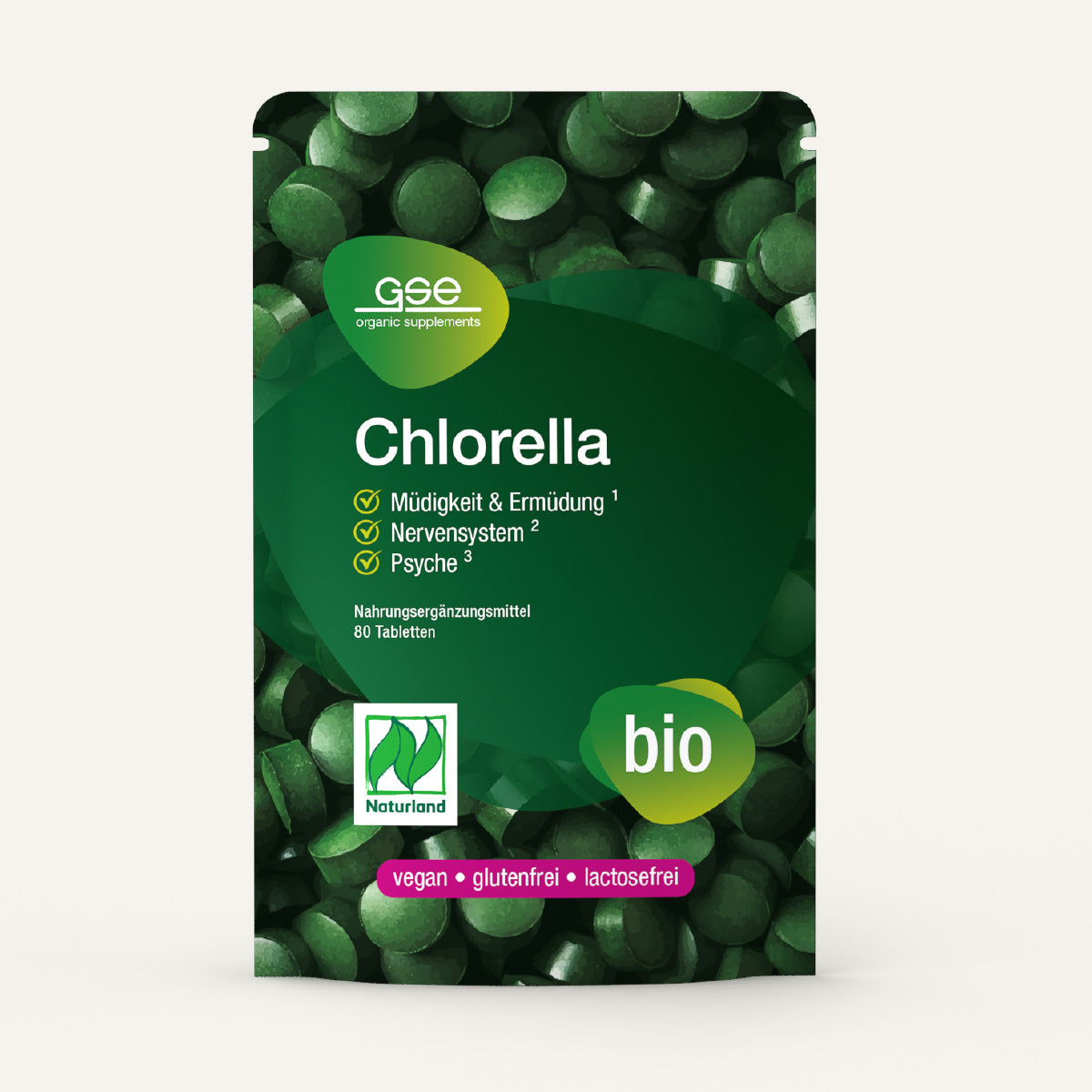 Eine grüne Packung von Naturland Bio Chlorella (Tabletten) von gse.organic.supplements. Die Vorderseite zeigt die deutschen Vorteile, vegane und biologische Etiketten, Informationen über Vitamin B12 und 60 Tabletten. Im Hintergrund sind leuchtend grüne Chlorella-Tabletten zu sehen.