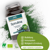 Eine Flasche Naturland Bio Spirulina (Tabletten) von gse.organic.supplements liegt auf grünem Pulver. Das Etikett weist auf die Vorteile für die Blutbildung, die Unterstützung des Immunsystems und die Verringerung von Müdigkeit hin; Symbole zeigen an, dass es vegan, glutenfrei, laktosefrei und biologisch ist.