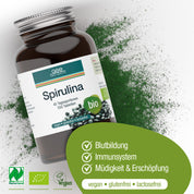 Eine Flasche Naturland Bio Spirulina (Tabletten) von gse.organic.supplements liegt auf einer weißen Fläche mit grünem Spirulina-Pulver. Dieses vegane, gluten- und laktosefreie Nahrungsergänzungsmittel ist reich an Eisen und unterstützt die Blutbildung, das Immunsystem und reduziert Müdigkeit.
