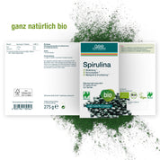 Eine Schachtel Naturland Bio Spirulina (Tabletten) von gse.organic.supplements-vegane Ergänzung in weißer Verpackung mit grünen Akzenten und deutschem Text, mit grünen Bio-Labels und Zertifizierungen. Nettogewicht: 275g. Spirulina-Pulver verstreut auf der Rückseite.