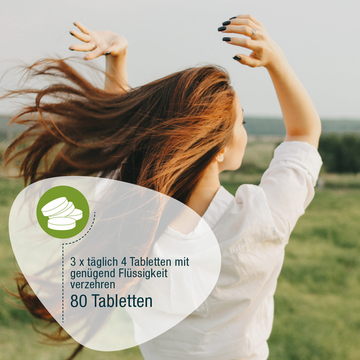Eine Frau mit langen braunen Haaren tanzt auf einer grünen Wiese unter einem bewölkten Himmel. Overlays zeigen Naturland Bio Spirulina (Tabletten) von gse.organic.supplements, eine vegane Dosierungsanleitung auf Deutsch und ein Tablettensymbol.