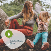 Eine lächelnde Frau und ein Kind sitzen im Freien auf felsigem Grund mit Bäumen. Das Kind hält einen Keks in der Hand. Ein grafisches Overlay zeigt ein Tropfensymbol und den Text "1 x täglich 1 Tropfen, Vitamin D3 Tropfen, 50 ml - gse.organic.supplements.