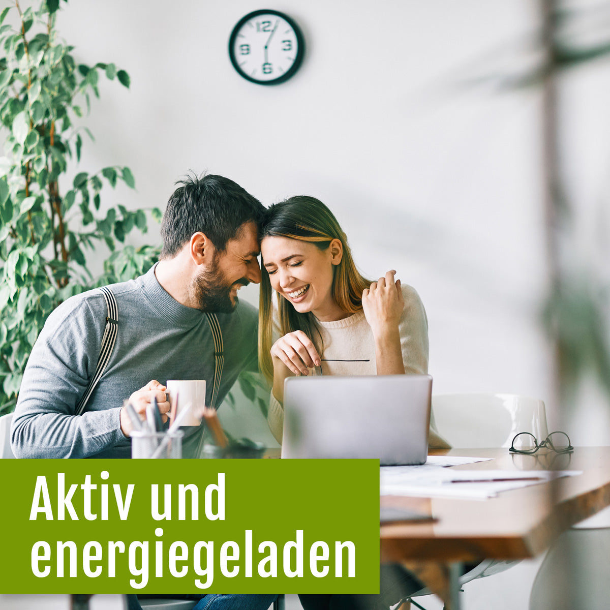 Klar! Hier ist der umformulierte Satz unter Verwendung Ihrer Produktdaten: Ein lächelnder Mann und eine lächelnde Frau sitzen gemeinsam an einem Tisch mit einem Laptop und Kaffeetassen, während eine Uhr und eine Pflanze den Hintergrund schmücken. Der deutsche Text lautet: „Aktiv und energiegeladen.“ Die Szene spiegelt den Energieschub wider, den man durch die Einnahme pflanzlicher Nahrungsergänzungsmittel wie „gse.organic.supplements Vitamin-B-Komplex (Bio)“ erhält, das reich an essenziellen B-Vitaminen